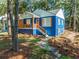 Cute blue house with orange door, stone path and wood accents at 1565 Ocala Sw Ave, Atlanta, GA 30311