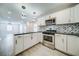 Modern kitchen with white cabinets, stainless steel appliances, and a breakfast bar at 1565 Ocala Sw Ave, Atlanta, GA 30311