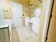 Bright bathroom featuring dual vanities, tile flooring, and a tub with white tile accents at 100 Cottonwood Pl, Stockbridge, GA 30281