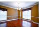 Formal dining room with hardwood floors, crown molding, decorative chandelier, and large windows providing natural light at 100 Cottonwood Pl, Stockbridge, GA 30281