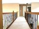 Upstairs hallway with plush carpeting and detailed black iron railing at 100 Cottonwood Pl, Stockbridge, GA 30281