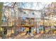 View of the back of townhomes with wood decks, awnings, and air conditioning units at 1605 Signal Flag Way, Lawrenceville, GA 30043