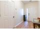 View of the entryway with hard wood floors, white walls, a small foyer table, and white doors at 1605 Signal Flag Way, Lawrenceville, GA 30043