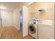 Bright laundry room featuring a white washer, dryer, and wire shelving for organized storage solutions at 1605 Signal Flag Way, Lawrenceville, GA 30043