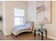 Cozy sitting nook with a chaise lounge, a window with blinds, and a decorative table with hardwood floors at 1605 Signal Flag Way, Lawrenceville, GA 30043