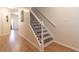 Staircase with wood-look floors, white risers, and a decorative black metal railing adding character to the home at 1605 Signal Flag Way, Lawrenceville, GA 30043