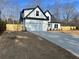 Charming white two-story home featuring a black roof, attached garage and a freshly seeded lawn at 3900 Arbor Se Ln, Conyers, GA 30094