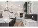 Bright open kitchen featuring a center island with marble countertops, pendant lights, and modern appliances at 3900 Arbor Se Ln, Conyers, GA 30094