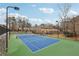 Community tennis court with well maintained green and blue surface and court-side seating at 1403 Parkaire Xing, Marietta, GA 30068