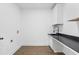 Laundry room with black countertop, white cabinets, and a utility sink at 4280 Atlanta St, Powder Springs, GA 30127