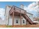 Back of house, with a two-story deck and stairs to the backyard. Hot tub is visible at 612 Cole Creek Dr, Dallas, GA 30157