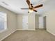 Bedroom featuring carpeted floors, neutral walls, ceiling fan, and two white doors at 275 Creek View Ln, Acworth, GA 30102