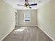 Well-lit bedroom with a ceiling fan and large window, showcasing a cozy carpeted floor at 275 Creek View Ln, Acworth, GA 30102