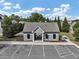 View of the community clubhouse featuring a parking lot, picnic tables, and tidy landscaping at 275 Creek View Ln, Acworth, GA 30102