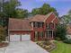 Two-story home with a brick facade, two-car garage, and manicured lawn at 561 Congress Pkwy, Lawrenceville, GA 30044