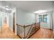 Light-filled upstairs hallway with hardwood floors and wooden staircase at 561 Congress Pkwy, Lawrenceville, GA 30044