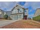 Two-story home with light blue siding, decorative trim, a red front door and mature landscaping at 1510 Lily Valley Dr, Lawrenceville, GA 30045