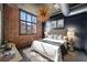 Cozy bedroom featuring exposed brick wall, large window, and stylish light fixture at 640 Glen Iris Ne Dr # 515, Atlanta, GA 30308