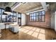 Bright living space with exposed brick wall, ductwork, and large windows, filled with natural light at 640 Glen Iris Ne Dr # 515, Atlanta, GA 30308