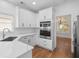 Well-lit kitchen featuring stainless steel appliances, white cabinets, and marble counters at 2224 Snug Ne Hbr, Marietta, GA 30066