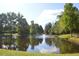 View of a peaceful pond with tree-lined shores and reflections on the water at 2224 Snug Ne Hbr, Marietta, GA 30066