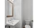 Cozy bathroom with pedestal sink, wooden-framed mirror, and commode, providing essential functionality with a classic design at 2531 High Brow St # 41, Duluth, GA 30096