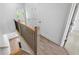 Upstairs landing featuring railing, wood-look flooring, white walls, and doorways leading to multiple bedrooms at 2531 High Brow St # 41, Duluth, GA 30096