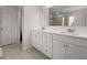 Bright bathroom with double vanity, white cabinets, quartz countertops, and framed mirror at 339 Garnet Dr, Acworth, GA 30101