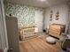 Cozy Bedroom with leaf-patterned wallpaper, wooden crib, and a comfortable rocking chair at 339 Garnet Dr, Acworth, GA 30101