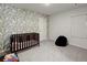 Bright Bedroom with palm wallpaper, carpet, and a dark wood crib at 339 Garnet Dr, Acworth, GA 30101