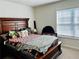 Bedroom with wooden bed frame, colorful bedding, and natural light streaming through the window at 339 Garnet Dr, Acworth, GA 30101