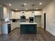 A modern kitchen features white cabinets, a dark island, stainless steel appliances, and beautiful pendant lighting at 339 Garnet Dr, Acworth, GA 30101