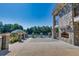 Stone patio with fireplace and tennis courts in the background at 3795 Greenside Ct, Dacula, GA 30019