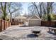 Cozy backyard featuring gravel ground cover, fire pit, wooden fence, and detached two car garage at 536 Moreland Ne Ave, Atlanta, GA 30307