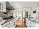 Bright kitchen features stainless steel appliances, white cabinets, stone counter tops and hardwood floors at 536 Moreland Ne Ave, Atlanta, GA 30307