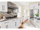 Bright kitchen with stainless steel appliances, white cabinets, stone counter tops and view of hallway through french doors at 536 Moreland Ne Ave, Atlanta, GA 30307