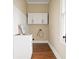 Well-lit laundry room with wooden floors, a stainless steel sink, white cabinets, and a faucet at 536 Moreland Ne Ave, Atlanta, GA 30307