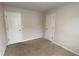 A simple bedroom with two white doors and neutral carpeting is move-in ready at 7540 Knoll Hollow Rd, Lithonia, GA 30058