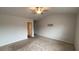 A carpeted bedroom with a ceiling fan and a doorway leading to other rooms at 7540 Knoll Hollow Rd, Lithonia, GA 30058