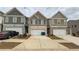 View of townhomes with driveways and garages, showcasing the building's exterior at 7540 Knoll Hollow Rd, Lithonia, GA 30058