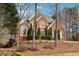 Two-story brick home with gray roof, landscaping, and mature trees at 4045 High Gables E, Cumming, GA 30041