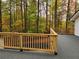 Large outdoor deck constructed of wood and grey mat, offering views of wooded lot at 3720 Riviera Dr, Cumming, GA 30041