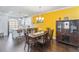 Open concept dining room with hardwood floors and yellow accent wall at 104 Laurel Crest Aly, Johns Creek, GA 30024