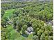 Aerial view of the house nestled among lush trees with a golf course in the background at 3711 Club Nw Dr, Kennesaw, GA 30144