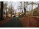 A long driveway leading to a charming home with a water view amid lush trees and landscaping at 3711 Club Nw Dr, Kennesaw, GA 30144