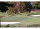 Close-up of a golf course with sand traps and a green, surrounded by trees at 3711 Club Nw Dr, Kennesaw, GA 30144