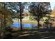 Tranquil view of golfers on a course and a lake with trees in the foreground at 3711 Club Nw Dr, Kennesaw, GA 30144