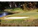 Picturesque golf course with a sand trap, pristine green, and a lake with a fountain backdrop at 3711 Club Nw Dr, Kennesaw, GA 30144