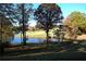 Picturesque golf course with a pond, trees, and a lush green fairway with sand traps in the distance at 3711 Club Nw Dr, Kennesaw, GA 30144