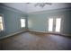 Large bedroom with tray ceiling, carpet, and double glass doors leading to the outdoors at 3711 Club Nw Dr, Kennesaw, GA 30144